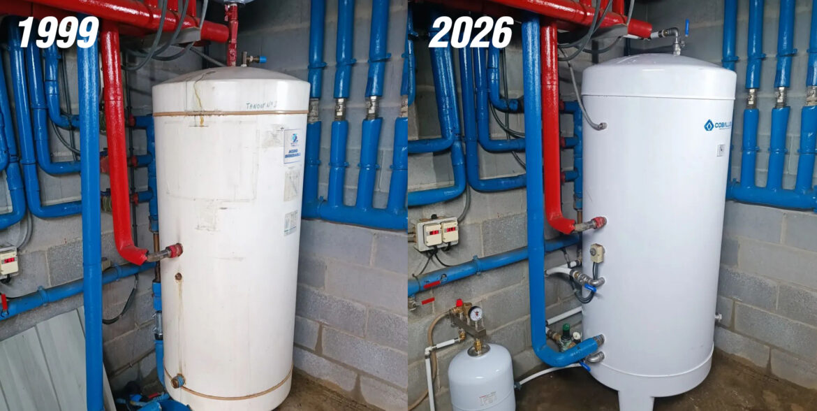 Comparativa antes/después de acumulador de agua sanitaria: modelo antiguo de 1999 muy desgastado junto a nuevo acumulador Coballes instalado en 2026, ambos en sala de calderas con tuberías azules y rojas.